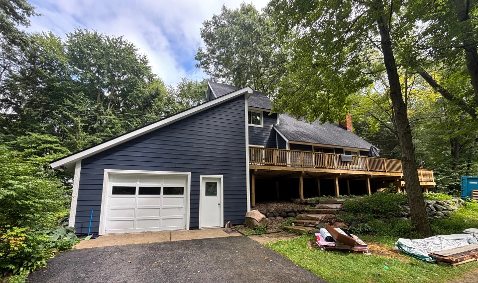 Navy siding in the woods - real Anchor Siding LLC job in mid-Michigan