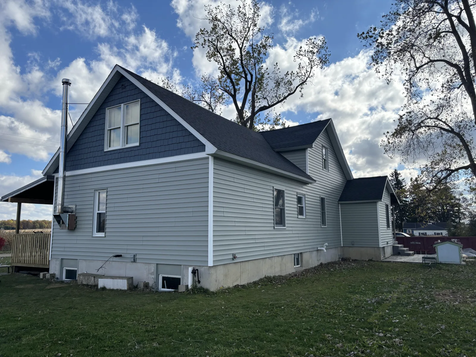 Blue home under a new dark roof - real Anchor Siding LLC job in mid-Michigan