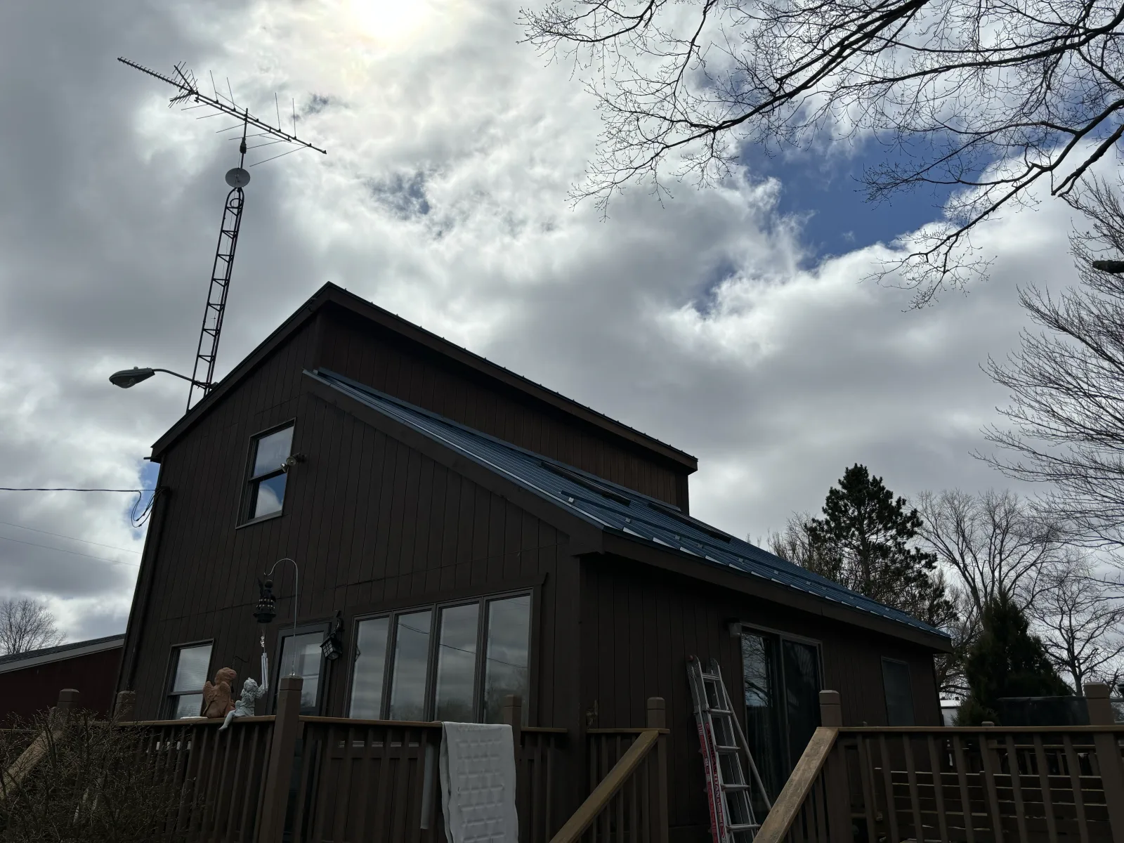 Dark metal roof on a wooded lot - real Anchor Siding LLC job in mid-Michigan