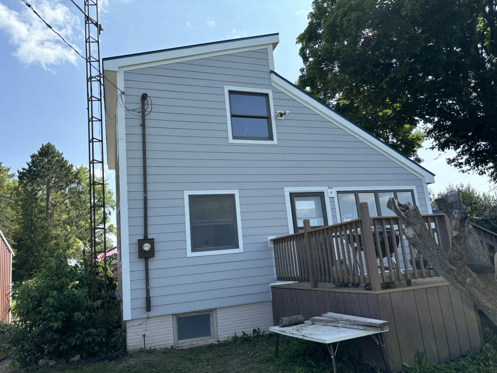Vinyl siding replacement on a light blue mid-Michigan home by Anchor Siding LLC